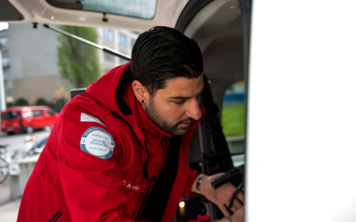 Mobimed-Mitarbeiter sichert einen Patienten im Fahrzeug vor der Abfahrt